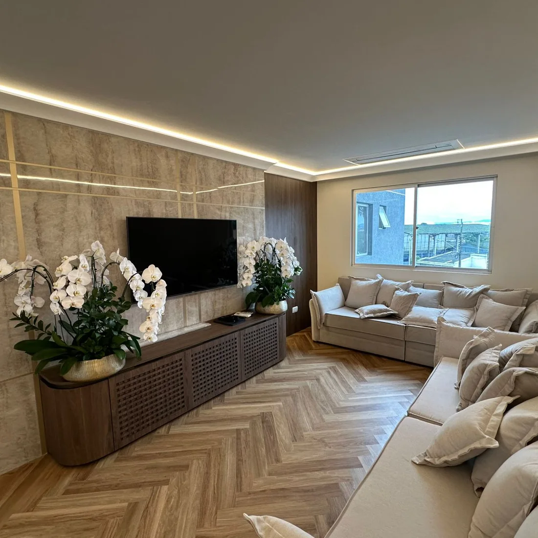 Sala de apartamento reformada com piso em espinha de peixe e forro iluminado